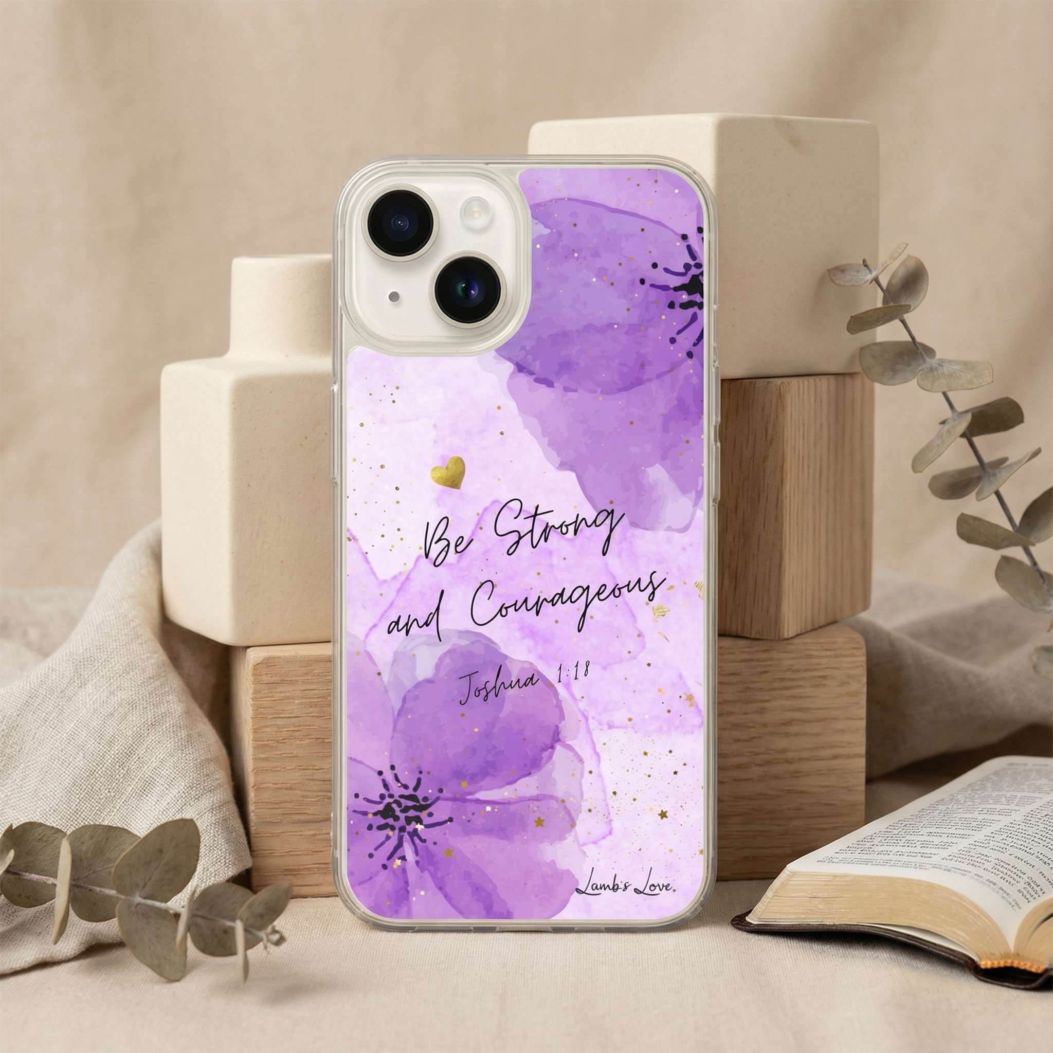Phone case with purple floral design and 'Be Strong and Courageous' text on a neutral background