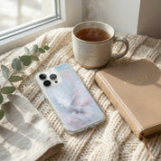 Phone case with a floral design on a textured surface next to a mug and Bible