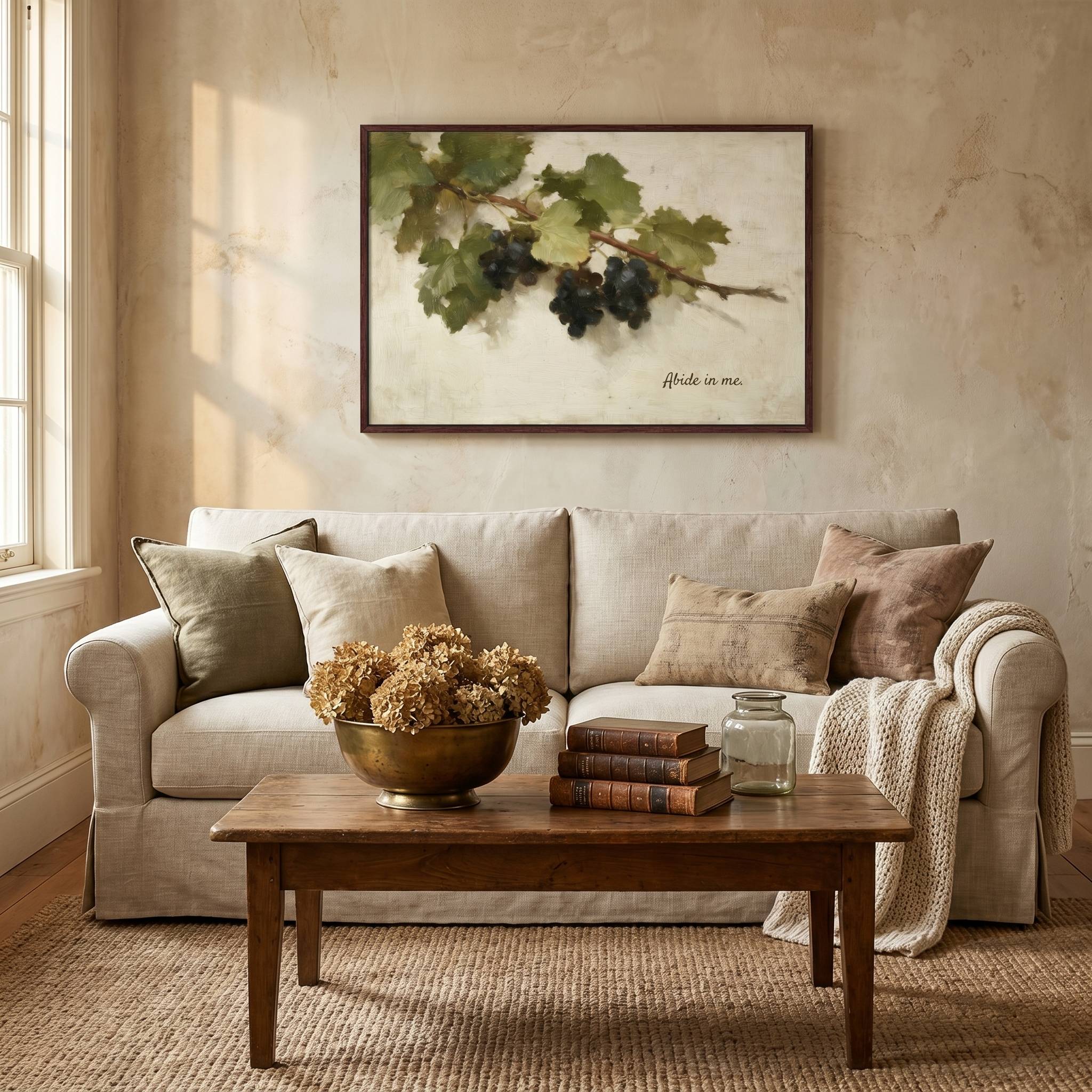 Abide in Me Christian wall art displayed above a living room sofa, featuring a vintage grapevine design inspired by John 15 in a warm, elegant farmhouse living space.