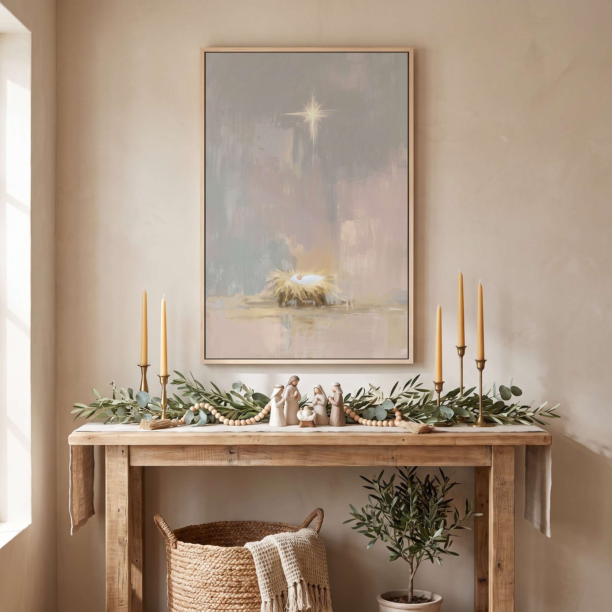 Framed Baby Jesus Nativity wall art above an entryway console decorated with candles and greenery, a peaceful Christmas display for a Christian home.