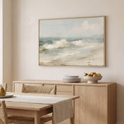 Framed vintage Psalm 46:10 Christian landscape canvas wall art featuring a coastal beach scene hanging above a light wood sideboard with stacked plates and a fruit bowl in a warm dining room.