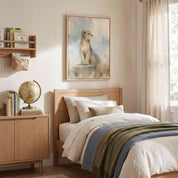 Be Strong and Courageous lion cub Christian kids wall art above a wooden bed with cream bedding and blue and green throws beside books and a globe.