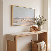 Framed Star of Bethlehem Christmas wall art above an entryway console styled with a small Nativity scene, dried branches, and a woven basket.