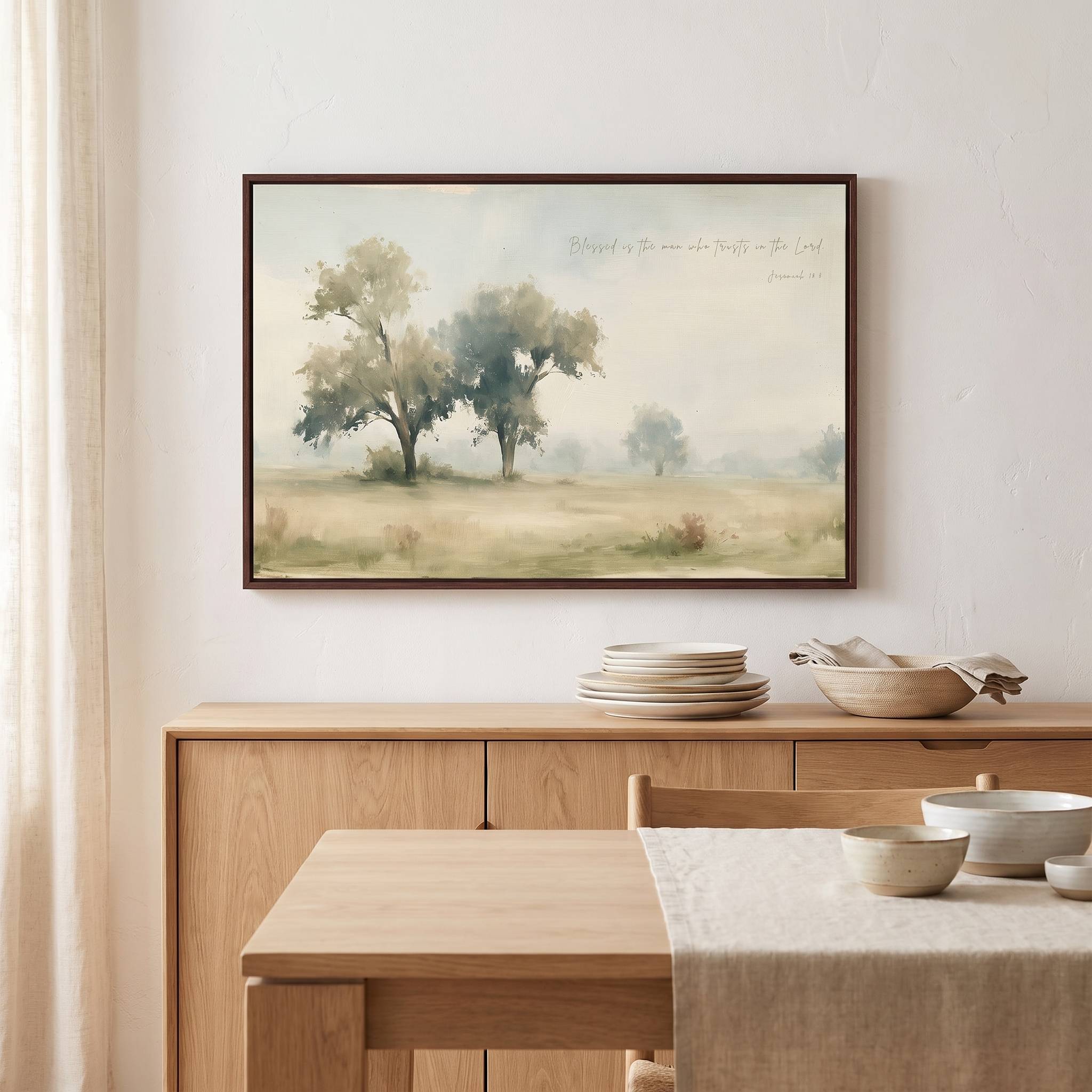 Framed vintage Jeremiah 17:7 Christian landscape canvas wall art hanging above a light wood sideboard in a soft organic modern dining room.