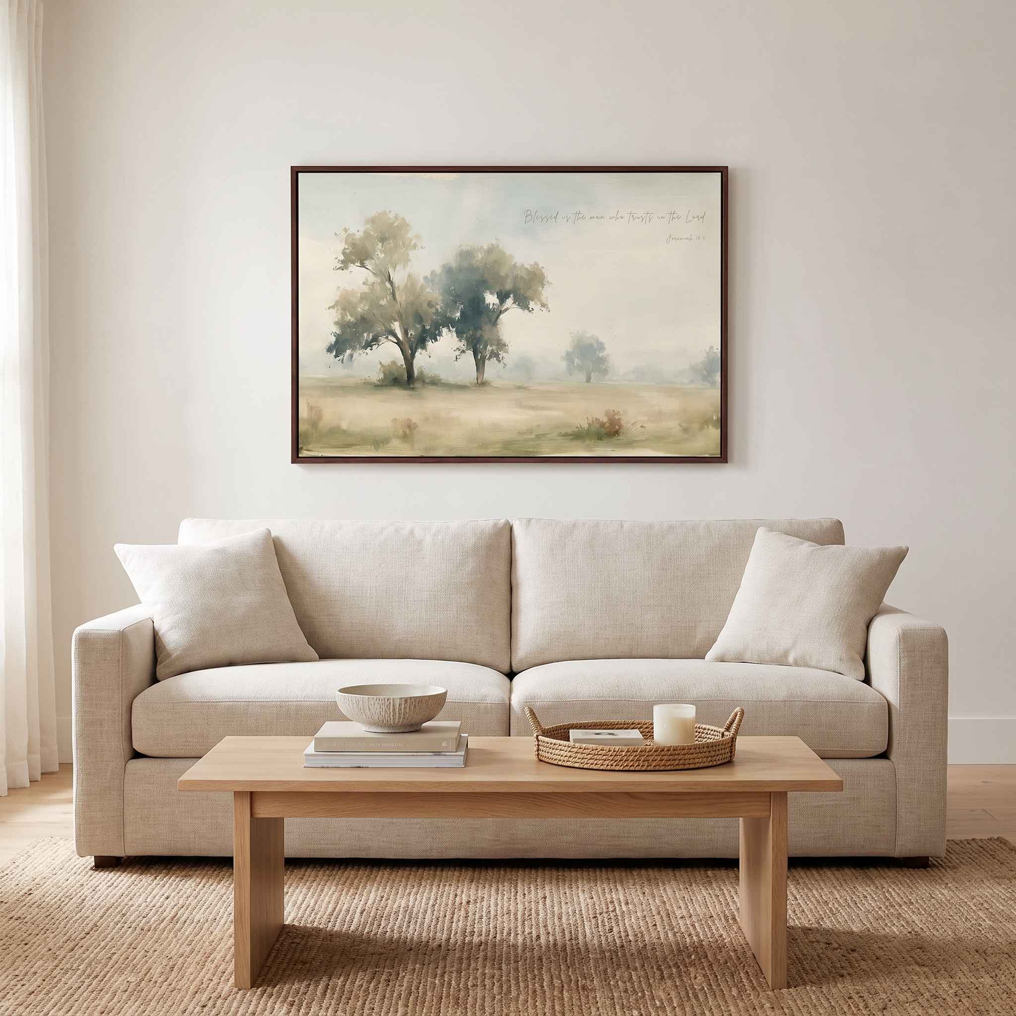 Framed vintage Jeremiah 17:7 Christian landscape canvas wall art hanging above a beige sofa and light wood coffee table in a soft organic modern living room.