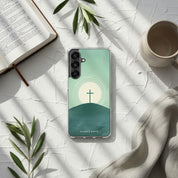 Minimalist Christian Samsung Galaxy case with a cross and sunrise design on a textured white surface with sun-drenched shadows, a ceramic mug, and an open book