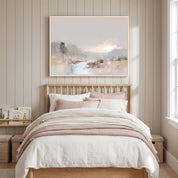Soft watercolor landscape wall art celebrating God’s creation, framed above a light wood bed in a neutral children’s bedroom with blush and white bedding.