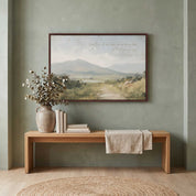 Framed vintage Christian landscape wall art titled Come to Me with Matthew 11:28 verse, displayed on a sage green wall above a light wood bench in a styled entryway.