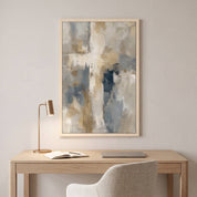 Framed contemporary abstract cross canvas wall art hanging above a light wood desk with a brass lamp in a modern home office workspace.