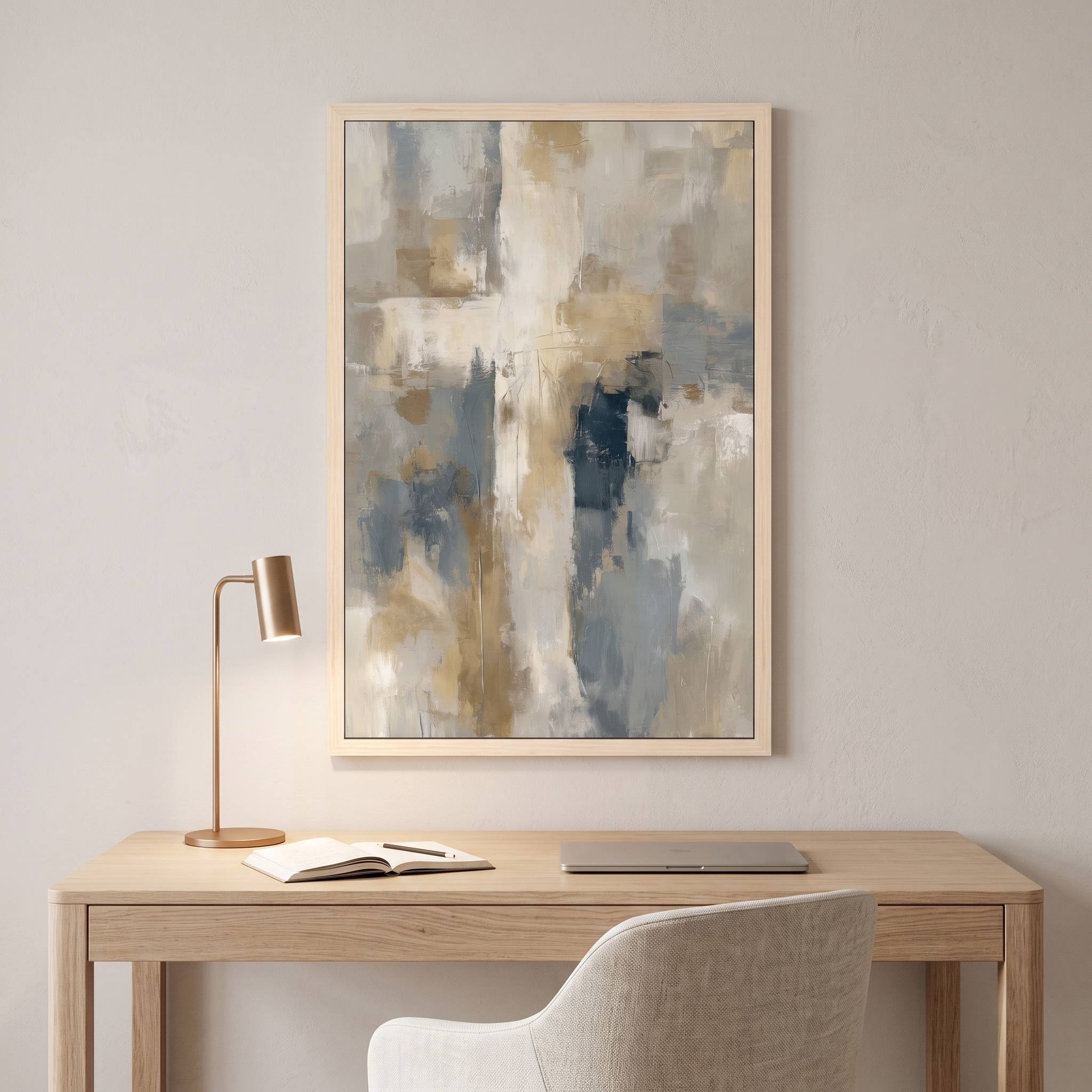 Framed contemporary abstract cross canvas wall art hanging above a light wood desk with a brass lamp in a modern home office workspace.