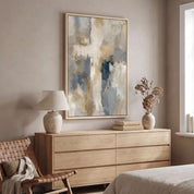 Framed contemporary abstract cross canvas wall art hanging above a light wood dresser in a serene, modern bedroom near a bedside lamp and window.