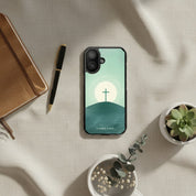 Christian MagSafe iPhone case with cross on the mountain design on desk with notebook and plants minimalist faith phone case