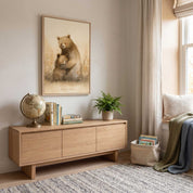 Framed Deeply Loved bear hug Christian kids wall art above a wooden cabinet with books and a globe, beside a cozy bedroom reading corner.