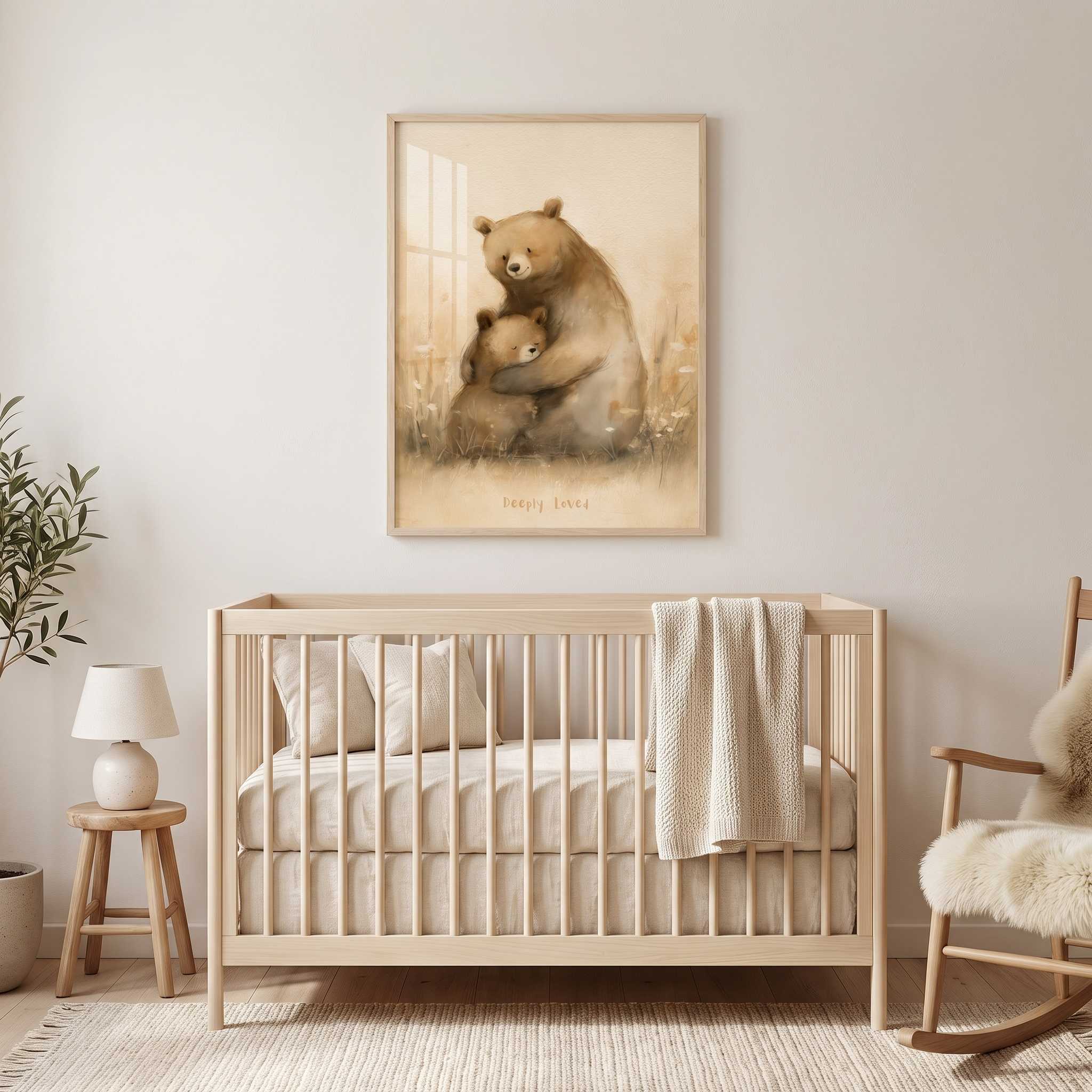Deeply Loved bear and cub Christian nursery wall art in a light wood frame above a crib, with cream bedding and a rocking chair in a neutral baby room.
