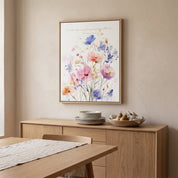 Ecclesiastes 3:11 watercolor floral Scripture wall art above a light wood dining room sideboard, with pastel wildflowers in pink, blue and purple.