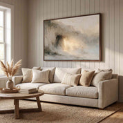 Framed abstract Empty Tomb Jesus Risen Christian landscape canvas wall art hanging on a vertical wood-paneled wall above a cream sofa in a bright modern living room.