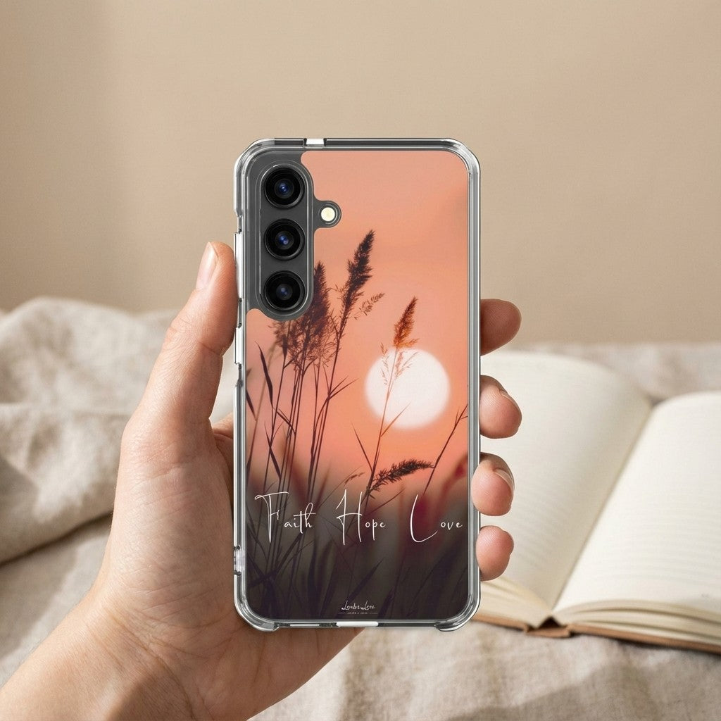 Phone case with sunset design and text held by a hand on a soft background