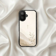 Faith Over Fear MagSafe® clear iPhone case featuring a minimalist Christian cross with soft neutral watercolor landscape and botanical artwork displayed on elegant white silk fabric in a modern neutral Christian aesthetic setting