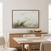 Framed vintage Isaiah 41:10 landscape canvas wall art hanging above a light wood sideboard with plates and a fruit bowl in a bright organic modern dining room.