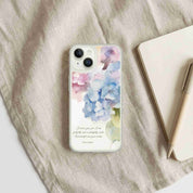 Phone case with floral design and text on a fabric surface