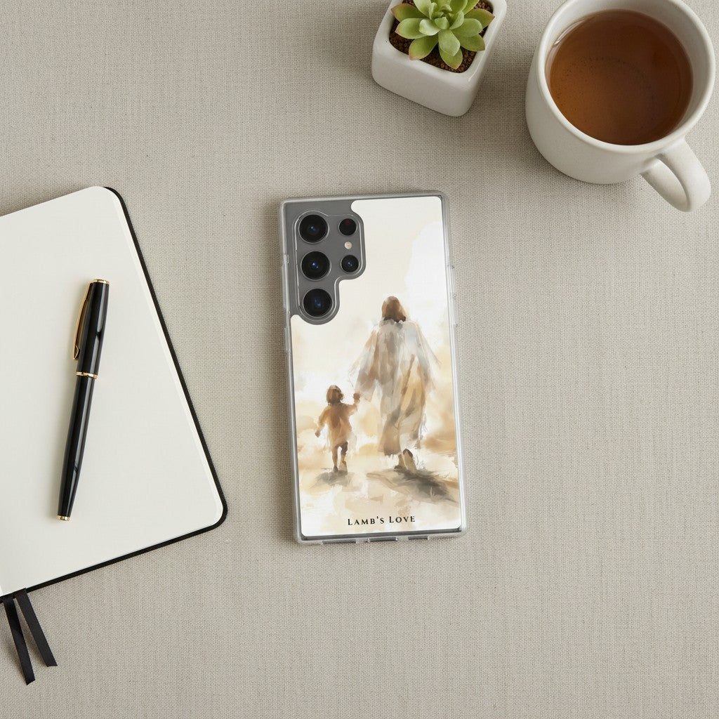 Christian Samsung Galaxy phone case with a watercolor illustration of Jesus walking with a child, arranged on a desk next to a notebook, pen, coffee mug, and a small succulent
