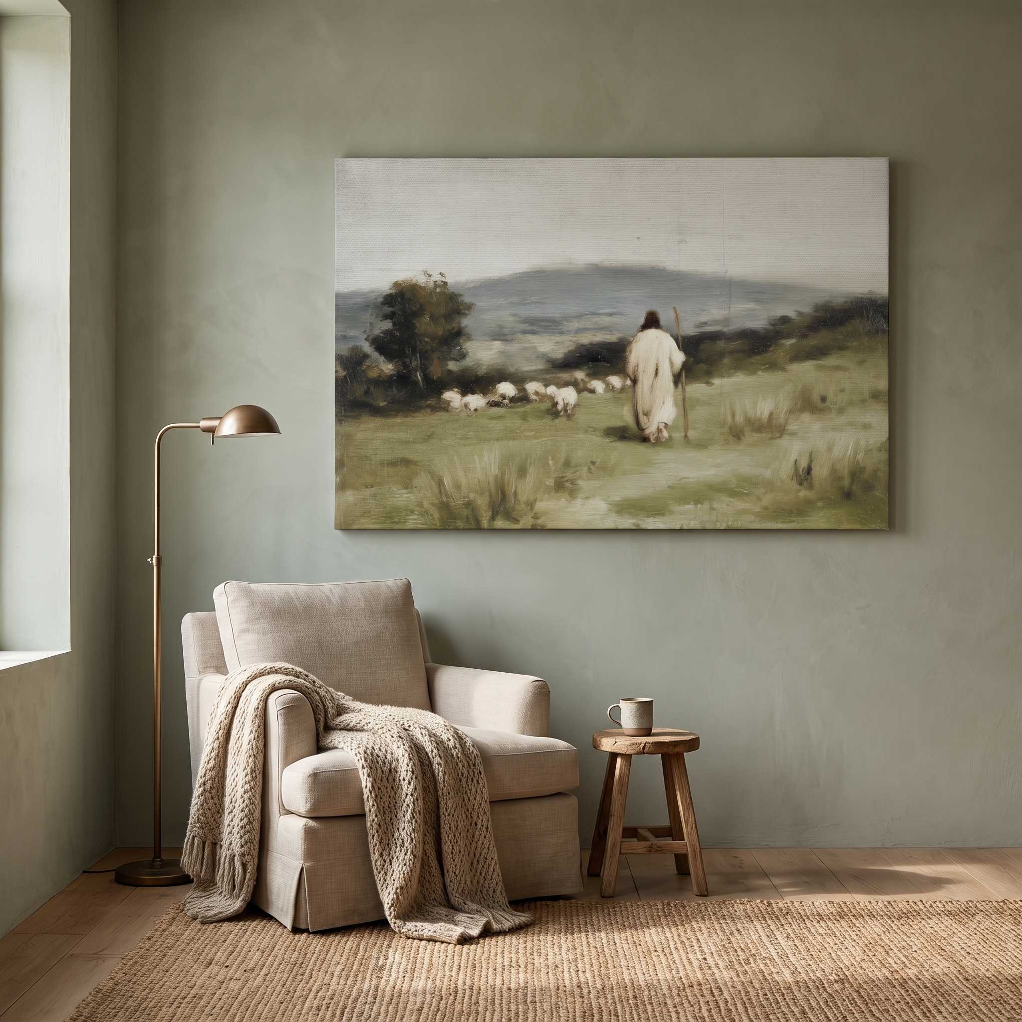 A framed landscape art print depicting a shepherd with sheep in a grassy field, displayed on a textured gray wall above a beige armchair in a styled living room setting.