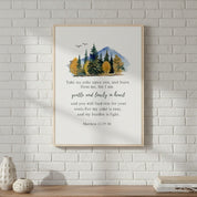 Framed artwork with nature scene and text on a white brick wall above a wooden shelf.