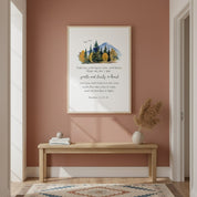 Framed watercolor mountain Christian wall art with Matthew 11:29–30, displayed above a minimalist desk on a warm brown wall.