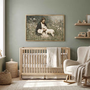 A framed horizontal vintage-style painting of Jesus the Good Shepherd holding a small lamb, hanging on a sage green wall above a light wood crib in a modern nursery setting.