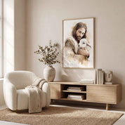 Jesus the Good Shepherd holding a lamb in framed Christian watercolor wall art above a wood console in a neutral living room.