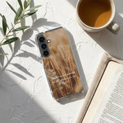 Christian Samsung phone case with wheat design and text next to a cup of coffee and open book on a light surface.