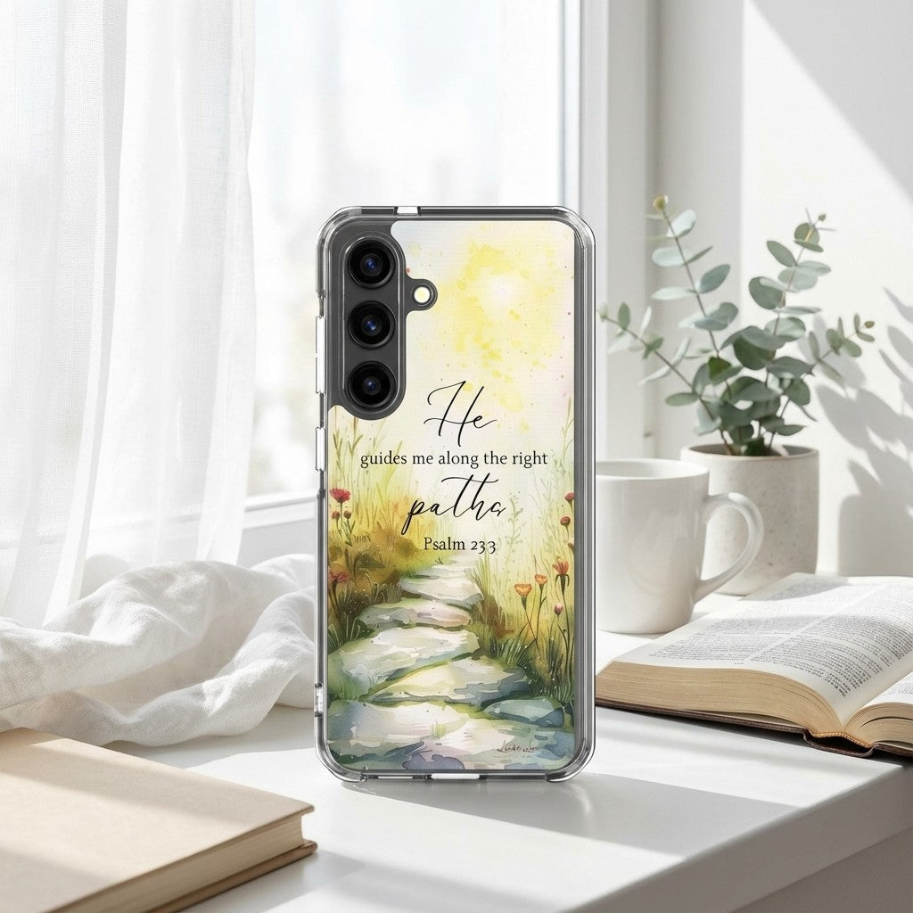 Christian Samsung case with nature design and text on a desk with books and a cup.