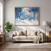 A large framed art print depicting a snowy winter forest with two deer hangs on a light gray wall above a beige sofa in a styled living room.