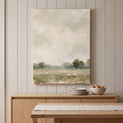He Restores My Soul Christian sheep landscape canvas above a wooden dining room sideboard with stacked plates and a bowl beneath a soft cloudy sky scene.