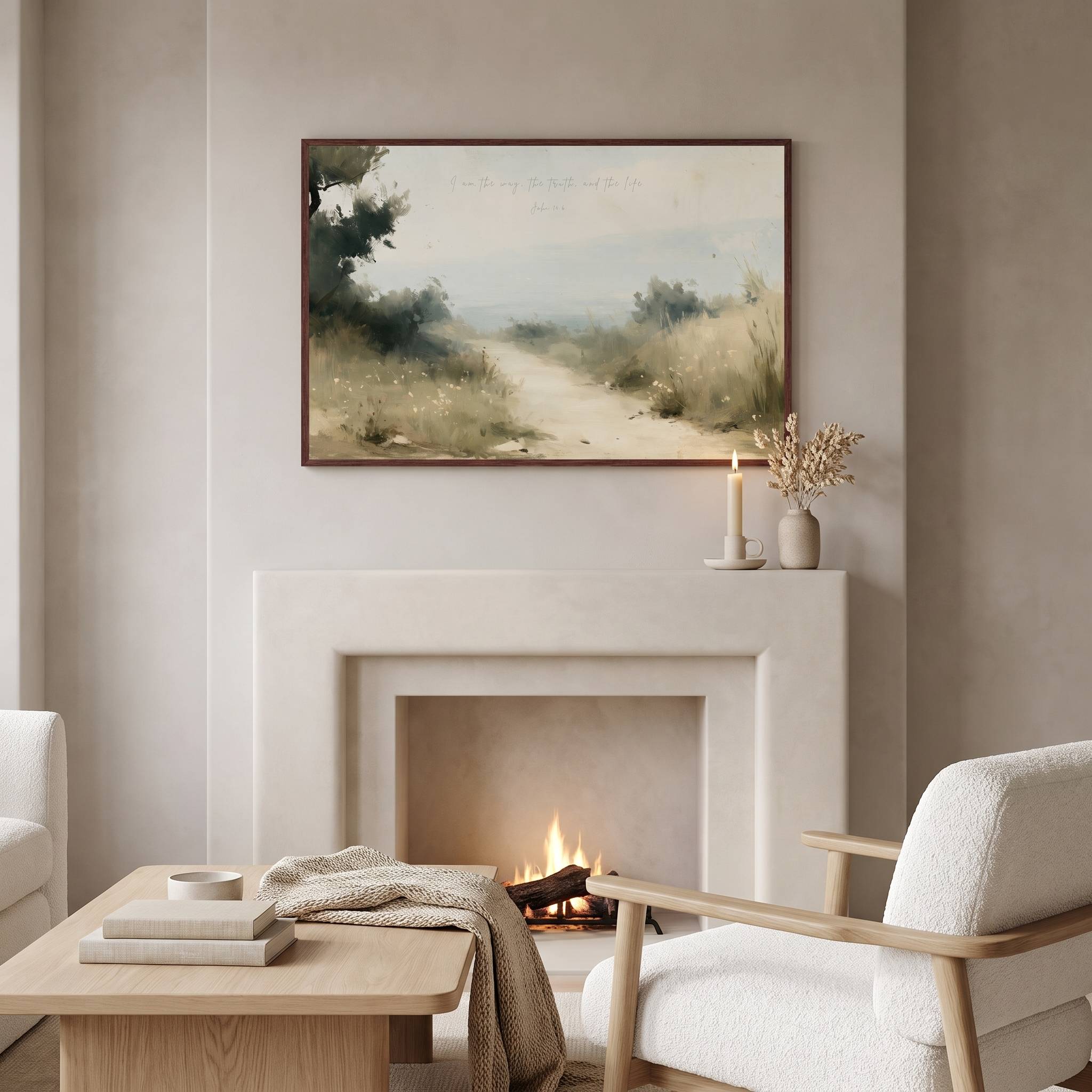 Framed vintage John 14:6 landscape canvas wall art hanging above a modern cream fireplace mantel with a wooden coffee table and armchair in a soft neutral living room.