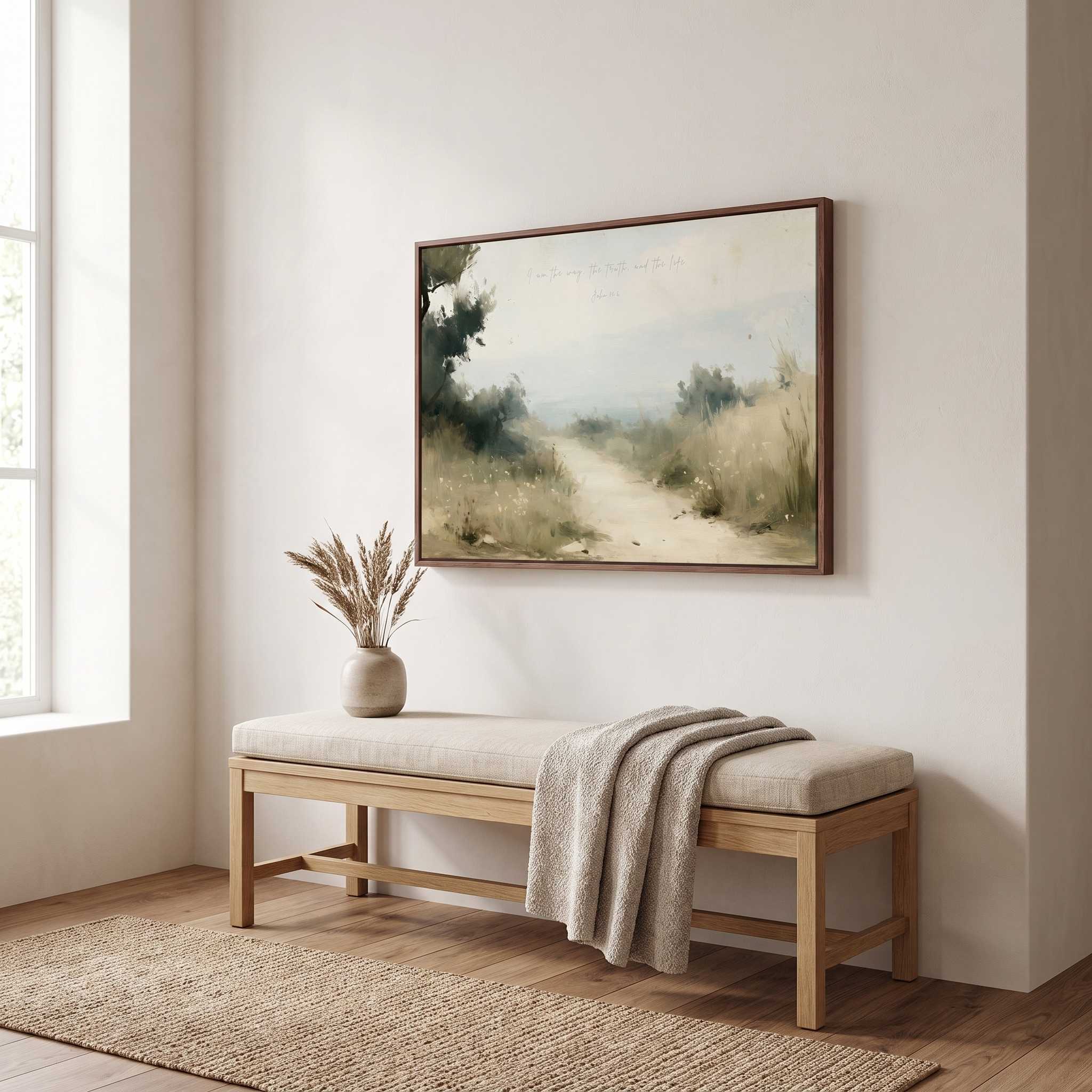 Framed vintage John 14:6 landscape canvas wall art hanging above a light wood bench with a throw blanket and ceramic vase in a soft organic modern hallway.