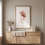 Framed Christian floral wall art titled Isaiah 30:15 featuring a watercolor poppy flower with "In quietness and trust is your strength", displayed on a beige paneled wall above a light wooden sideboard in a soft organic modern dining room.
