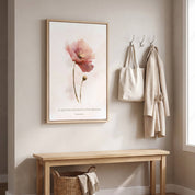 Framed Christian floral wall art titled Isaiah 30:15 featuring a watercolor poppy flower with "In quietness and trust is your strength", displayed on a beige wall above a wooden console bench in a bright minimalist entryway.