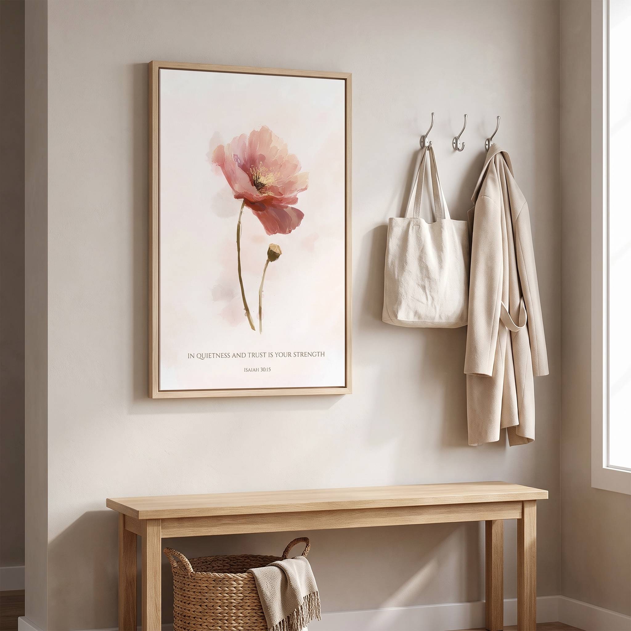 Framed Christian floral wall art titled Isaiah 30:15 featuring a watercolor poppy flower with "In quietness and trust is your strength", displayed on a beige wall above a wooden console bench in a bright minimalist entryway.