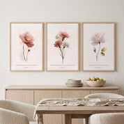 Three framed Christian floral wall art prints featuring Isaiah 30:15, Psalm 103:5, and Lamentations 3:23 Scripture verses with watercolor flowers, displayed as a 3-piece triptych above a wooden sideboard in a soft organic modern dining room.