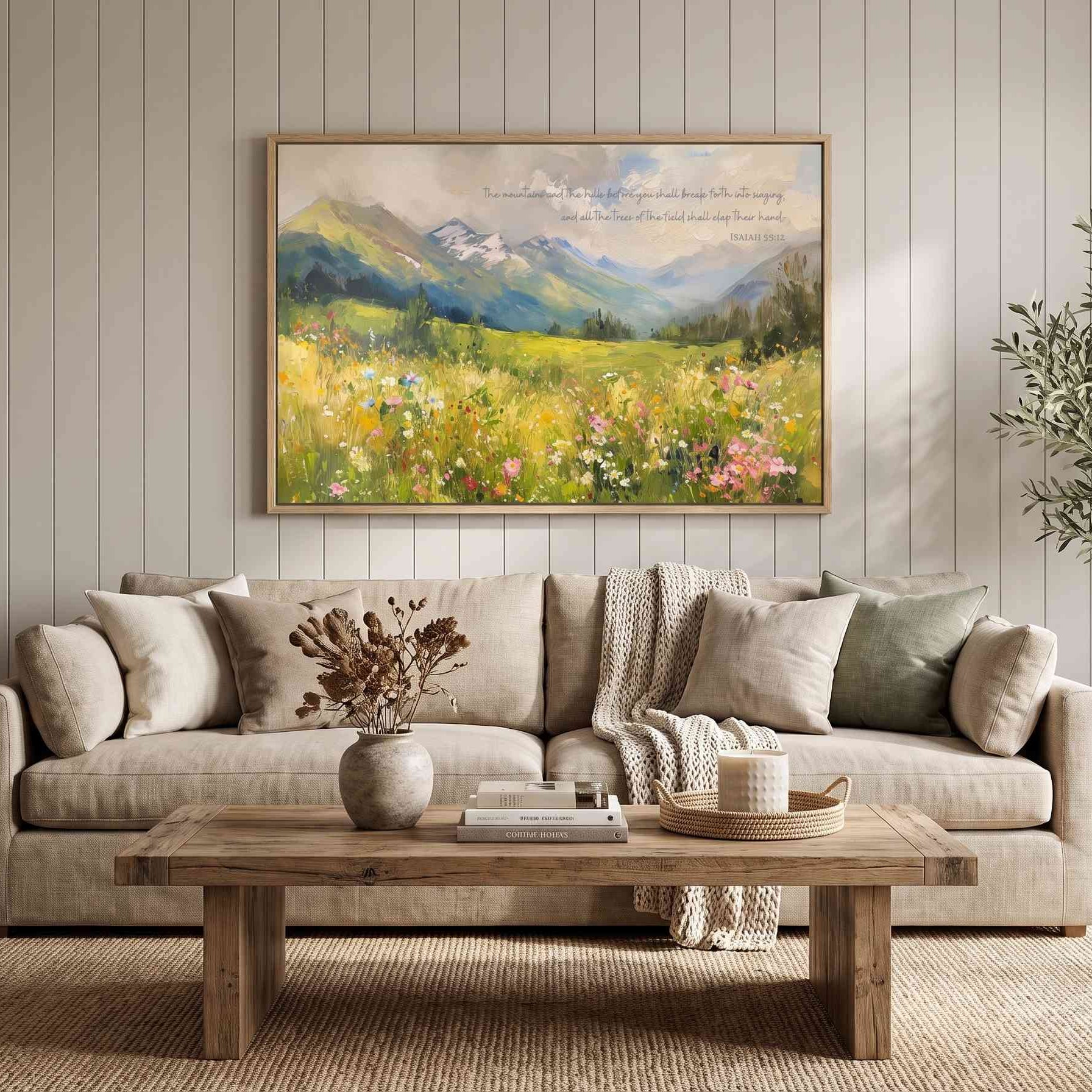 Framed Isaiah 55:12 Christian landscape wall art by Lamb's Love, featuring a colorful wildflower mountain scene above a sofa in a modern living room.
