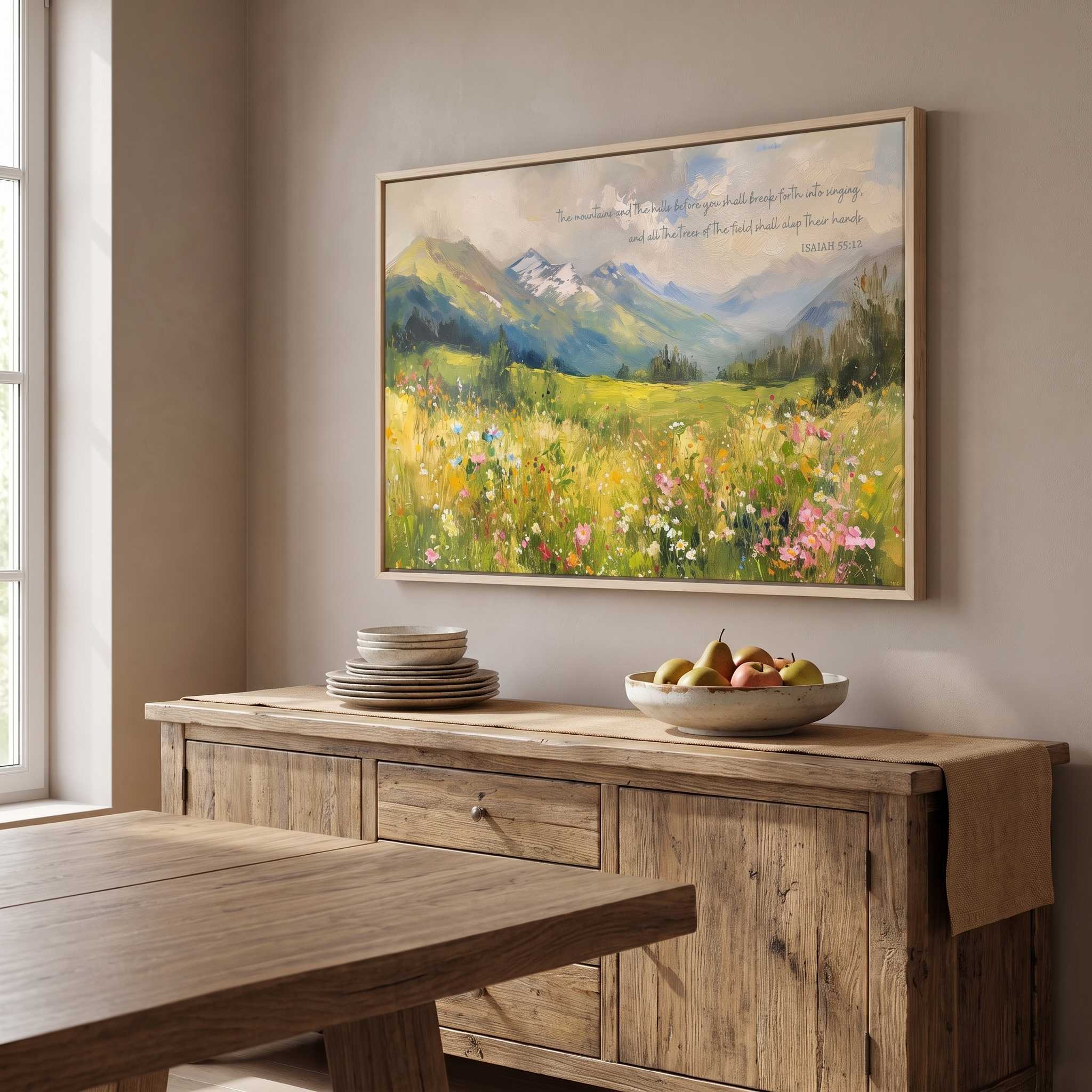 Isaiah 55:12 mountain landscape wall art with colorful wildflowers, displayed above a rustic wooden sideboard in a dining room.