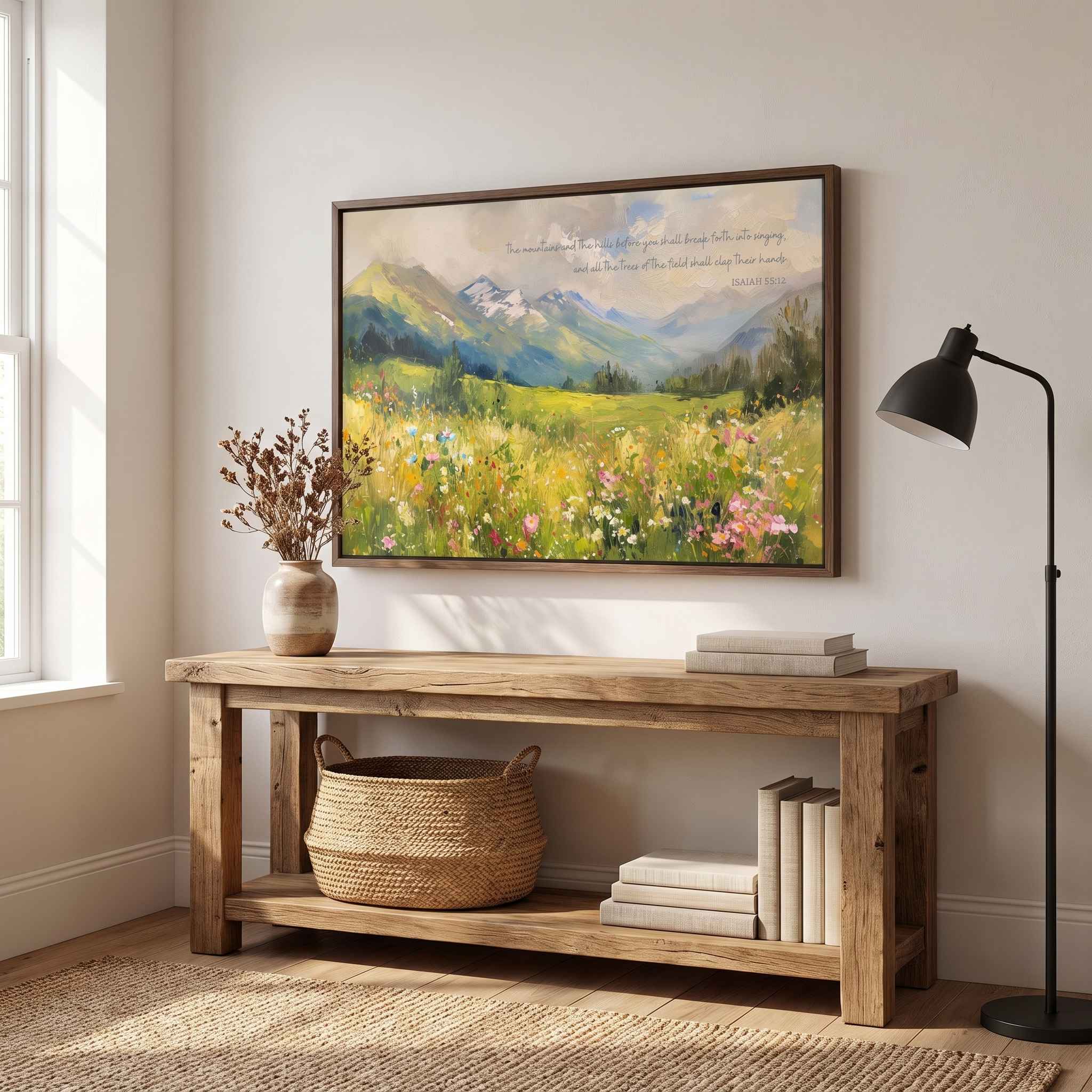 Isaiah 55:12 mountain landscape Scripture wall art with a colorful wildflower meadow, styled above a rustic console table in a bright living room.