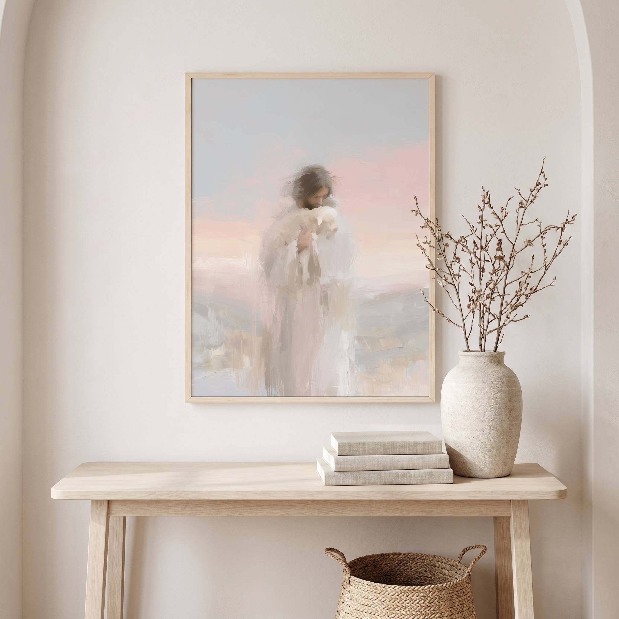 Watercolor Christian wall art of Jesus holding the lost sheep, displayed in a bright entryway above a console table with a vase and books.