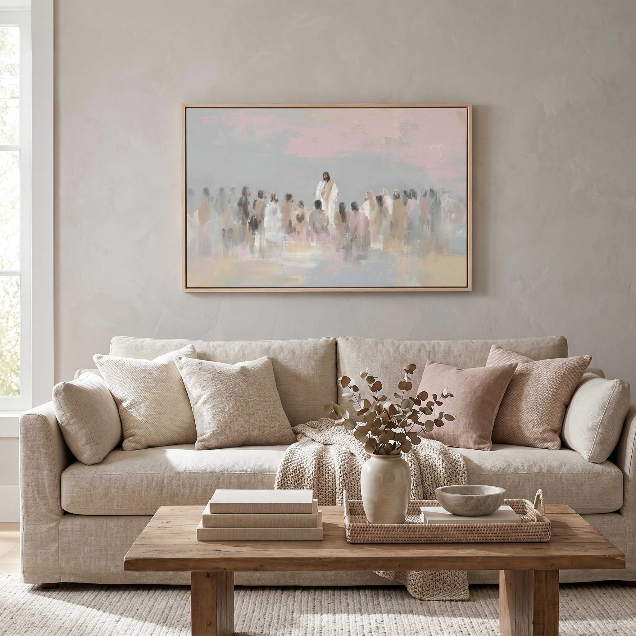 Framed Jesus teaching the people wall art above a beige living room sofa, depicting Christ and a gathered crowd in a calm watercolor scene.