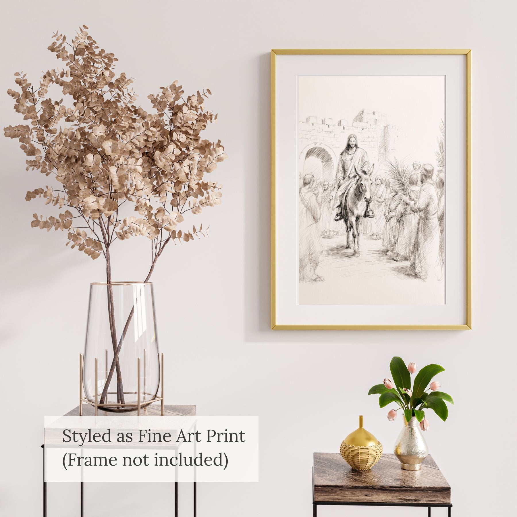 Minimalist Jesus Triumphal Entry line art sketch styled as a fine art print in a gold frame, hanging on a white wall next to a glass vase with dried branches and a small green plant.