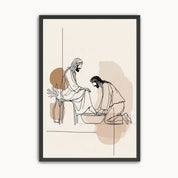 Minimalist line art print of Jesus washing His disciple's feet in a black frame with neutral beige abstract shapes on a light wall.