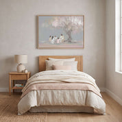 Framed Christian wall art of Jesus with children under a tree styled above a bed in a soft pastel nursery and kid's room.