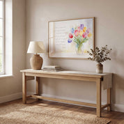 John 14:27 Christian wall art in a natural wood frame above an entryway console table with a lamp, books, and eucalyptus.