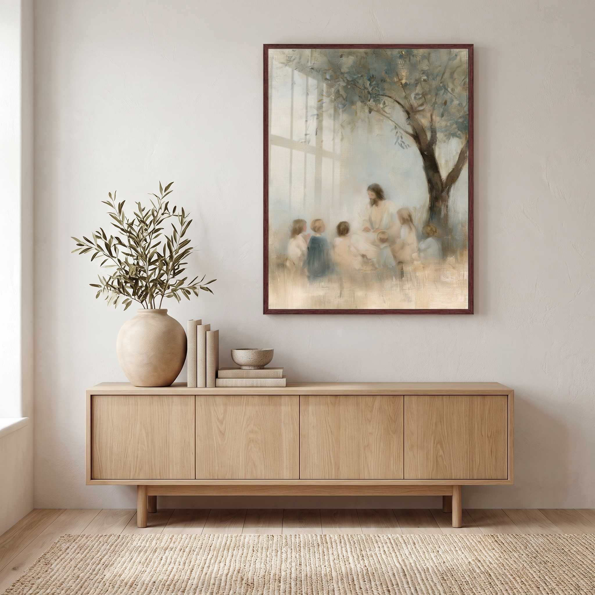 Framed Let the Little Children Come Jesus with children Christian wall art above a wooden sideboard with books and a leafy vase in a neutral living room.